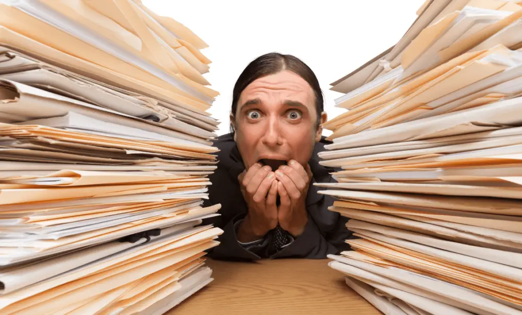 man biting nails looking stressed as he stares at important paperwork he's prepared in case of an emergency during a long trip. happytogetheranywhere.com