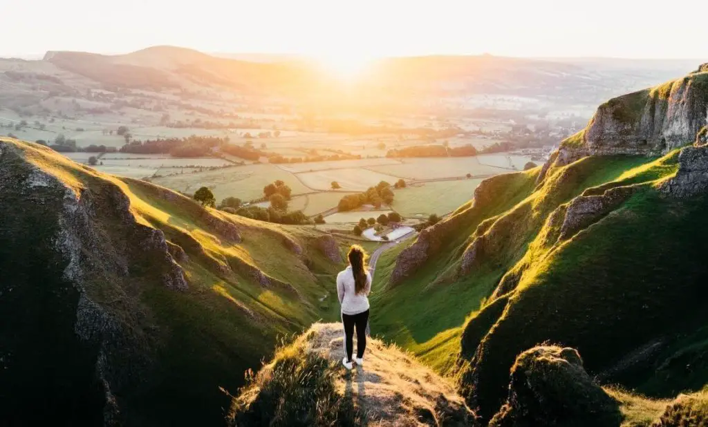 woman in white sweater standing and looking over mountain view. happytogetheranywhere.com